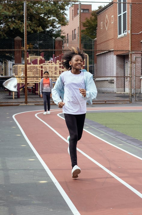 Smiling black athlete running on track